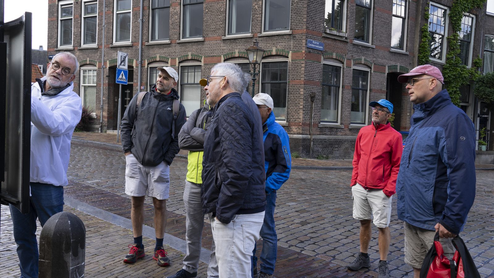 Gids vertelt een groep over de route tijdens een stadswandeling in Dordrecht met gids